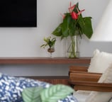 sala de tv com vaso de flores vermelhas