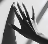 a woman's hand casting a shadow on a wall for step into your divine feminine coaching by LVFLVX.COM