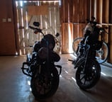 two motorcycles parked in a garage with a bike