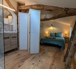 a bedroom with a bed and a wooden floor