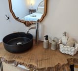 a bathroom sink with a wooden table and a mirror