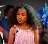 Two children performing in a production of Seussical Jr., with the girl in a pink fringe costume pla