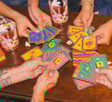 a group of people holding cards and playing cards