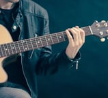 a man in a leather jacket playing guitar