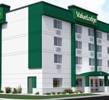 a hotel with a large green sign that says,'welcome to the hotel