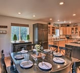 Spacious dining area adjacent to a fully equipped kitchen with forest views at Moose Creek Lodge.