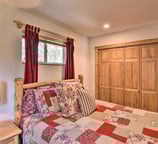 Guest bedroom with pinewood closet and cozy mountain quilt décor at Moose Creek Lodge.