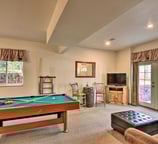 Alternate view of Moose Creek Lodge game room with pool table, TV, and bar seating.