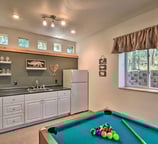 Basement kitchenette at Moose Creek Lodge with mini-fridge, sink, and pool table for entertainment.