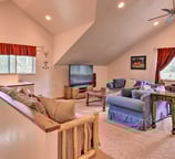Comfy upstairs lounge with blue couches and a large TV.