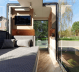 Interior of tiny home pod with bed and large glass windows