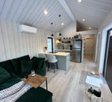 Cozy interior of tiny home pod with kitchen and seating