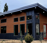 Modern tiny home pod with large windows and dark trim