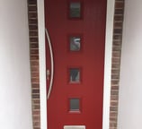 a new red composite front door with 4 squares of glass and curved long handle