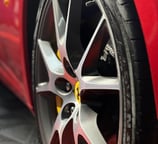 raudonas ferrari automobilis su geltonu ratu ir juoda padanga