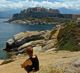 femme assise sur les rochers en corse à calvi