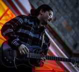 Dimitri Janiak guitariste, joue de la guitare dans la rue de la mairie devant le beffroi de Douai