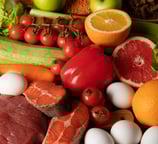 Mand met diverse voedingsmiddelen zoals vlees, groenten en eieren, symbool voor gezonde voeding.