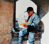 a man sitting on a ledge in a stone wall