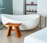 a bathtub with a wooden stool and a stool with a stool