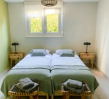a bedroom with two beds and a lamp