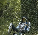 Homme mystérieux en armure et tenue galonnée mystérieusement assis contre un arbre