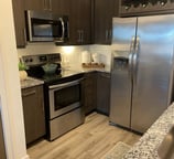 a kitchen with a stainless steel refrigerator and a refrigerator