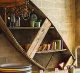 a wooden boat on a table with plates and bowls