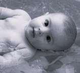 photo en noir et blanc d'un bébé dans son bain