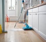 a woman in white shirt cleaning a wooden floor