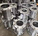 a bunch of metal pipe flanged flanges and a lot of metal