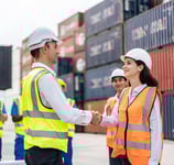 a man and woman shaking hands in front of a container container
