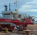 a red and white boat docked at a dock