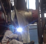 a man welding a piece of metal with a welding torch