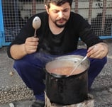 a man is cooking in a potted potted on a stove
