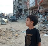 a young boy standing in front of a building