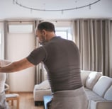 Pareja adulta sonriendo y haciendo un ejercicio de baile en su sala de estar.
