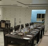 a restaurant with a large table and chairs
