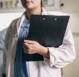 a woman in a hospital gown holding a clipboard