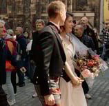 a man and woman in plaidered kilts walking down a street