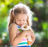 A young girl holding her pet guinea pig
