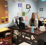 a teacher sitting at a desk in a classroom