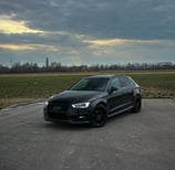 A black car parked in a parking lot
