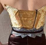 The back of a gold brocade and brown satin evening gown