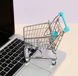 a shopping cartonce with a shopping cartonce in front of a laptop