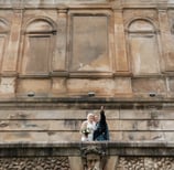 a bride and groom standing on a balcony