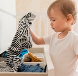 image d'enfant choisissant seul ses vêtements dans un tiroir