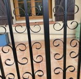 Détail de garde-corps en ferronnerie avec volutes noires, réalisé sur mesure par un artisan ferronnier à Toulouse pour une te