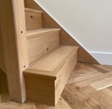 An oak herringbone floor with matching plank on the staircase