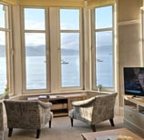 The living room at Gourock Seaview Holiday Let with a large window with sea views and a television